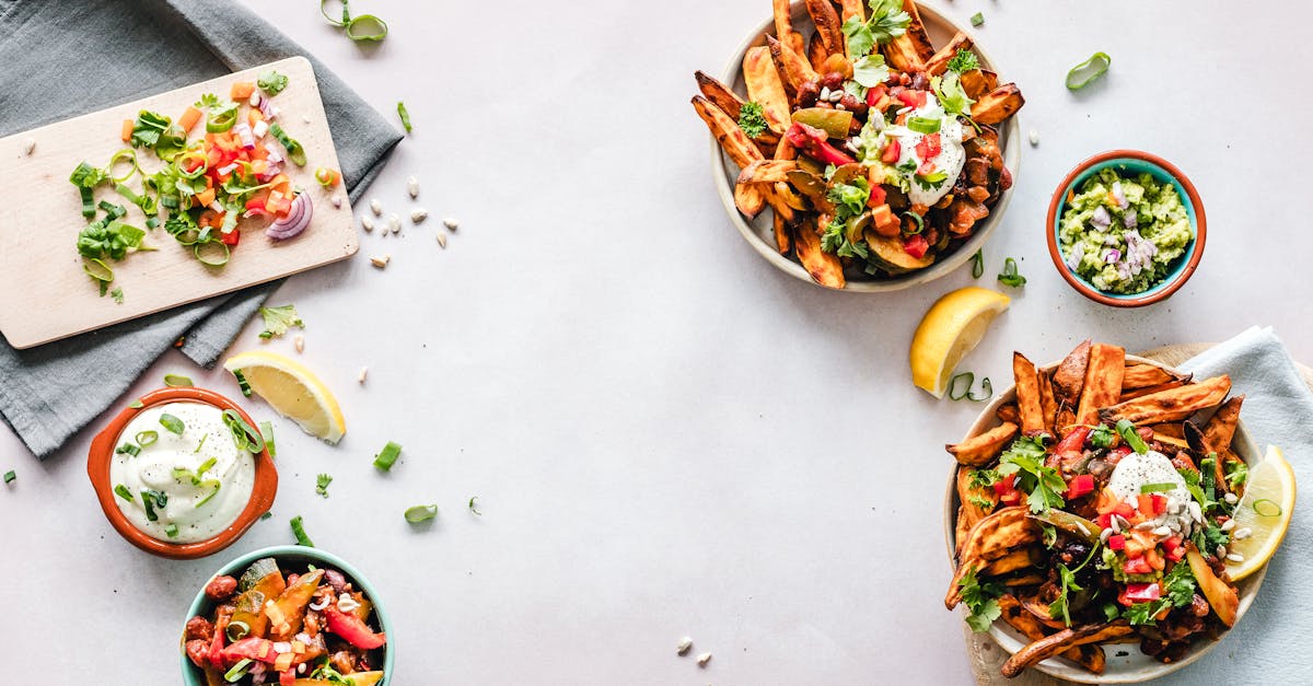 Colorful flat lay featuring sweet potato fries, guacamole, and fresh veggies, perfect for a healthy meal.